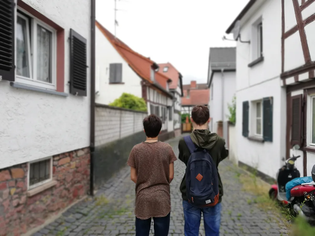 Zwei Jugendliche gehen durch eine schmale Altstadtgasse.